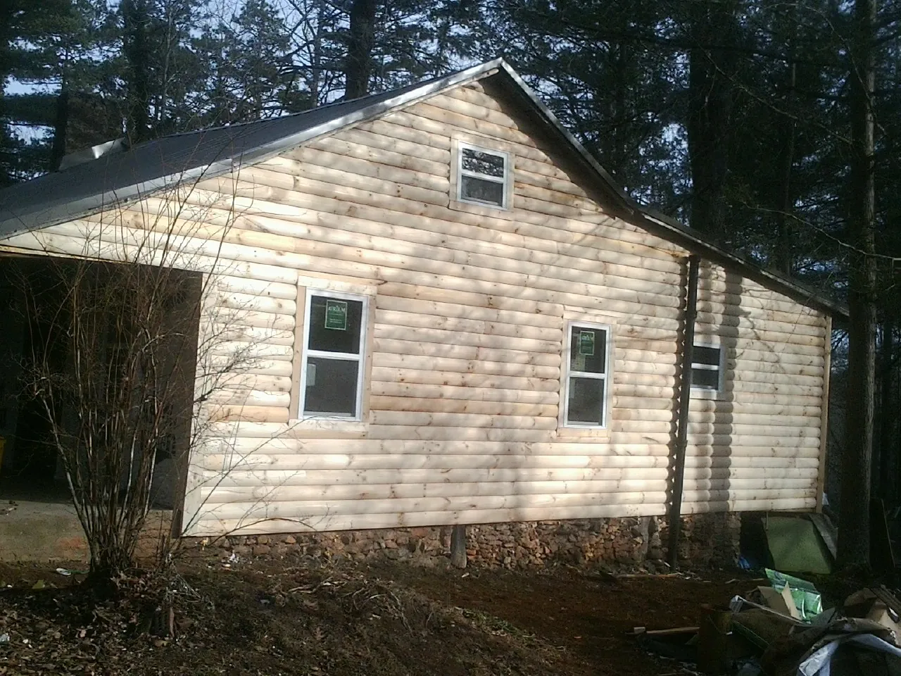 New log siding and dark metal roofing on a gable end in Buchanan