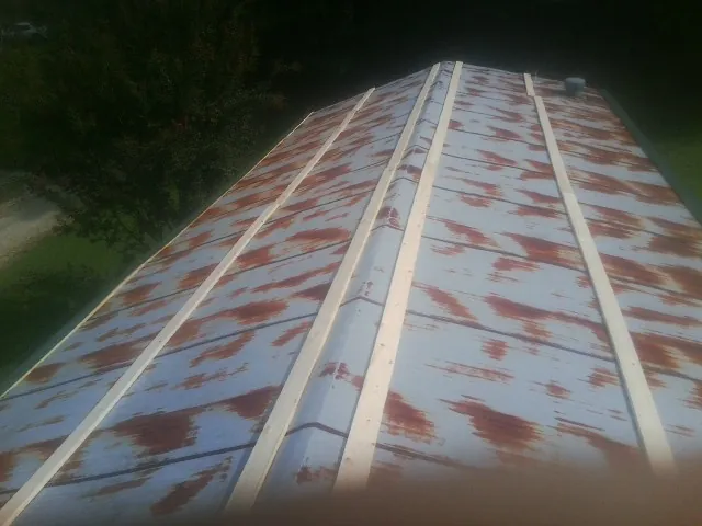Rusted metal roof panels with new wood purlins before replacement — Storm Damage Roof Repair in Buchanan by Roofing Brothers